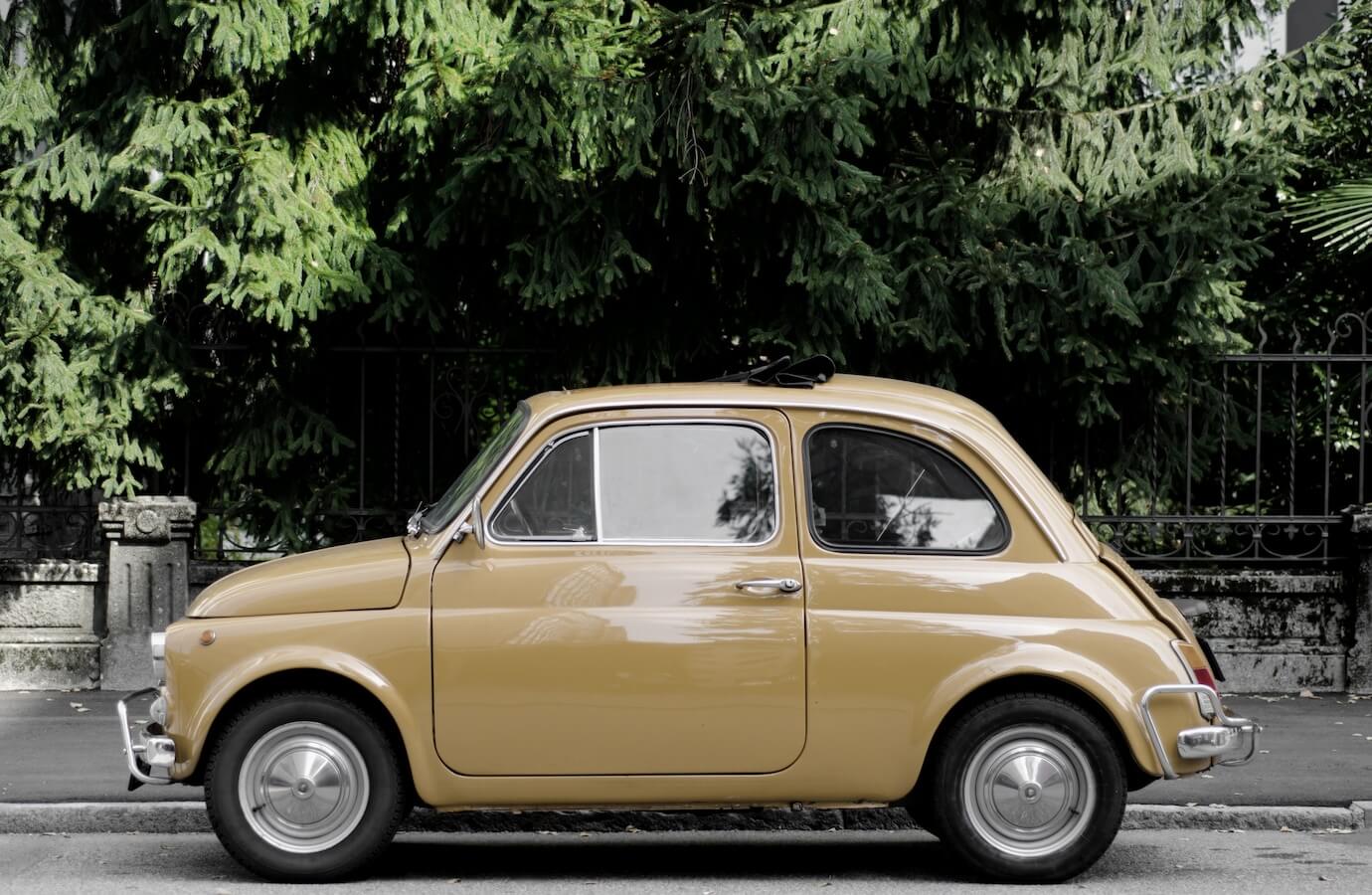 vintage-car-street-surrounded-by-trees-sunlight_181624-34480