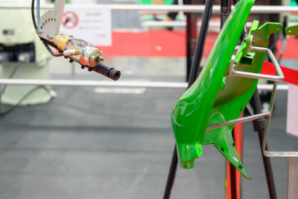 automatic spray gun is coloring a part of motor cycle